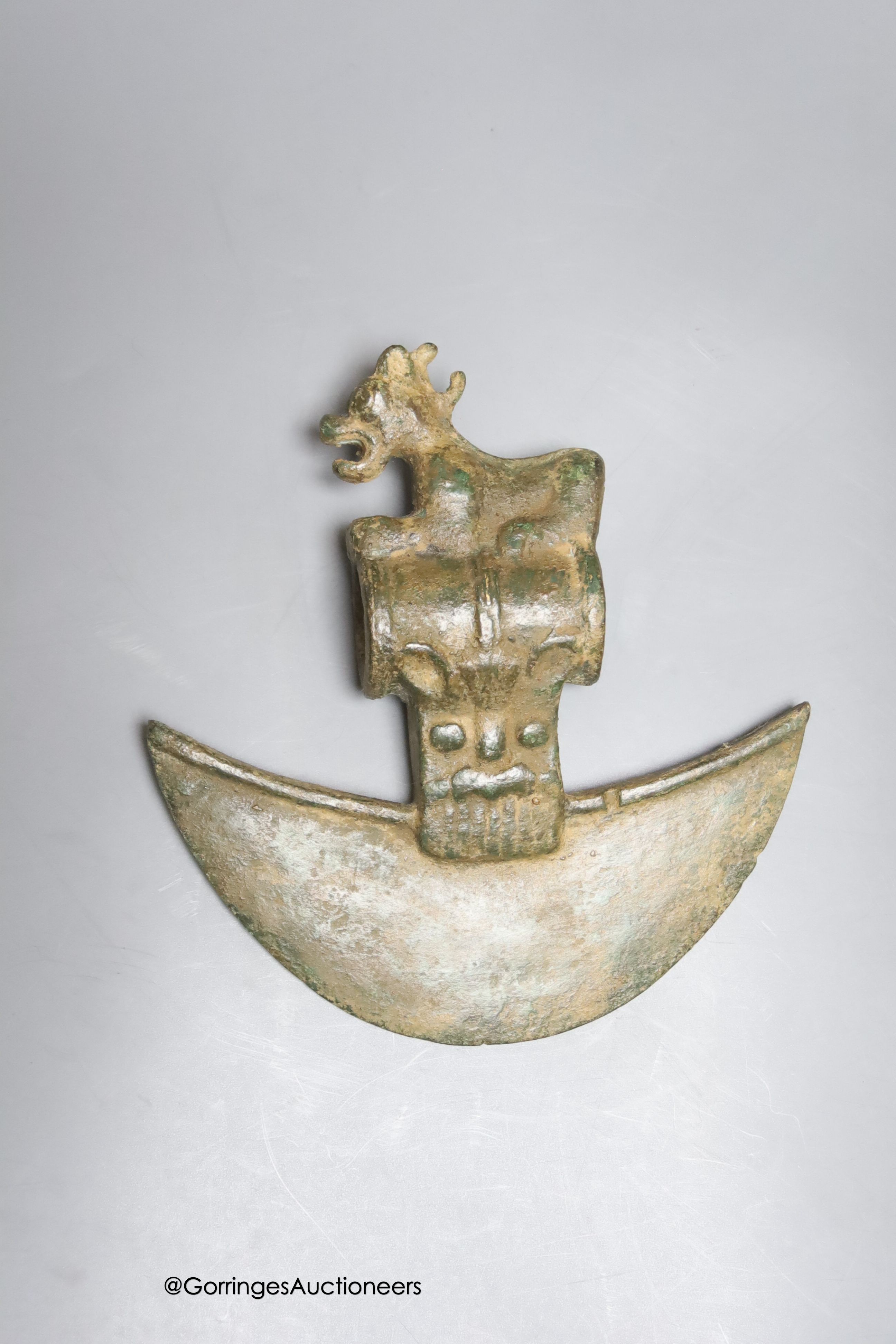 A Luristan style bronze axe head on stand